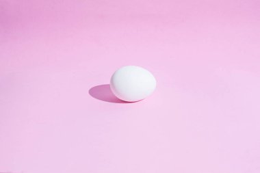 Pembe bir zemin üzerinde beyaz Paskalya yumurtalarından yapılmış gıda arka plan. Tasarım, görsel sanatlar, minimalizm, üst görünüm, düz yatıyordu, sert ışık, sert gölgeler. 
