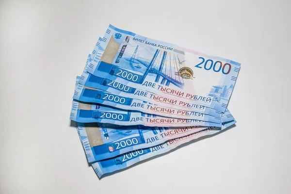 Birçok yeni banknot iki bin Rus rublesi vardır. Beyaz arka planda nakit kağıt para.