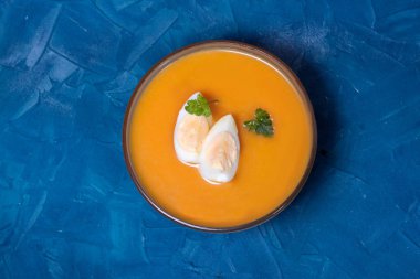 Salmorejo cordobes, üzerinde mavi arka planda yumurta ve yeşillikler bulunan gazpacho 'ya benzeyen tipik İspanyol domates çorbası. Kopyalama alanı olan üst görünüm.