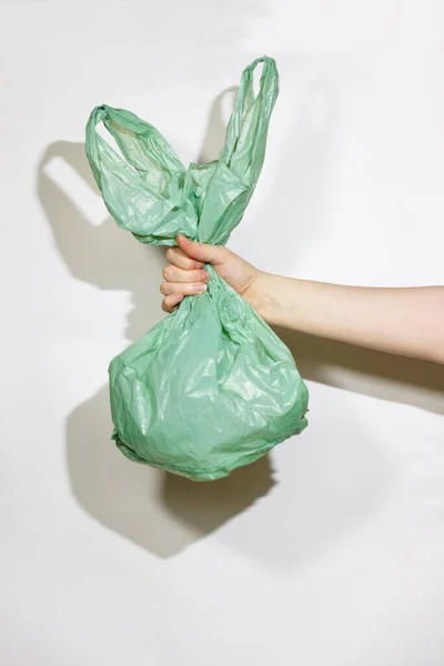 Groene Plastic Zak Vrouwelijke Handen Een Witte Achtergrond Het Concept Rechtenvrije Stockafbeeldingen