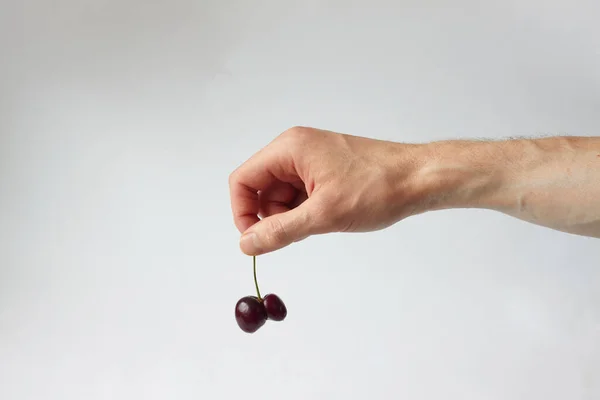 Homme Tient Deux Vilaines Cerises Avec Ses Doigts Formes Étranges — Photo