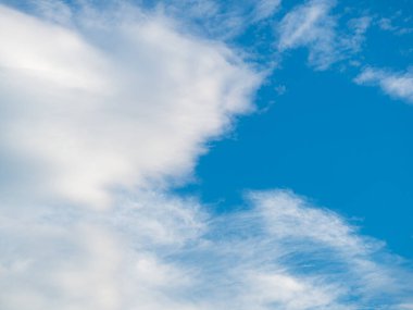 Mavi gökyüzü arkaplanına karşı beyaz bulutlar