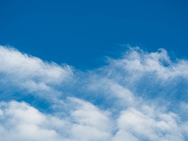 Mavi gökyüzü arkaplanına karşı beyaz bulutlar