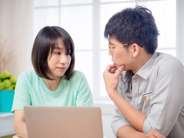 Dizüstü bilgisayarın önünde tartışan iki genç.