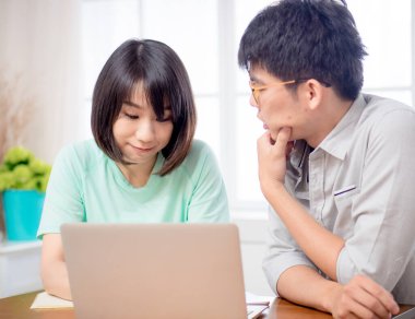 Dizüstü bilgisayarın önünde tartışan iki genç.