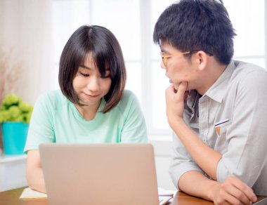 Dizüstü bilgisayarın önünde tartışan iki genç.