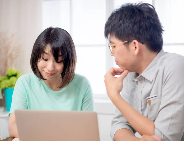 Two Young People Discussing in front of Laptop