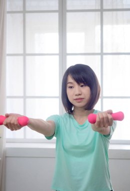 Dambıl kaldıran genç bir kız.