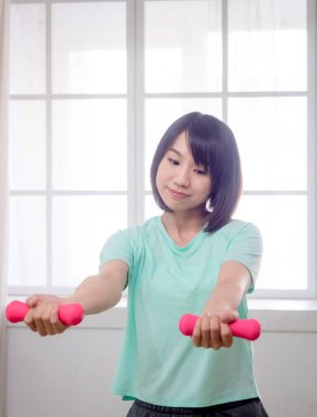 Dambıl kaldıran genç bir kız.