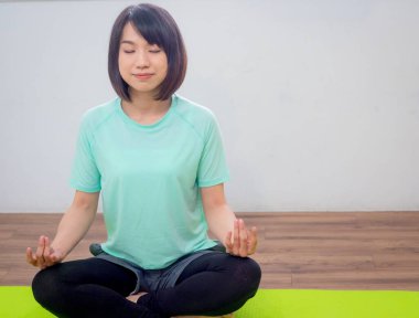 Yoga yapan, gülümseyen çekici bir Yogi kadını.