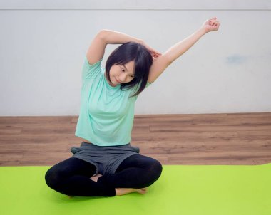 Yoga yapan, gülümseyen çekici bir Yogi kadını.