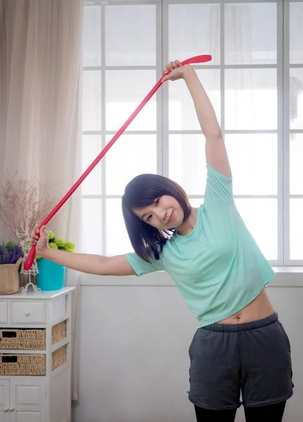 Young girl doing aerobic exercise with fitness band
