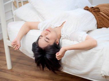 Genç bayan yatakta uzanmış dinleniyor.