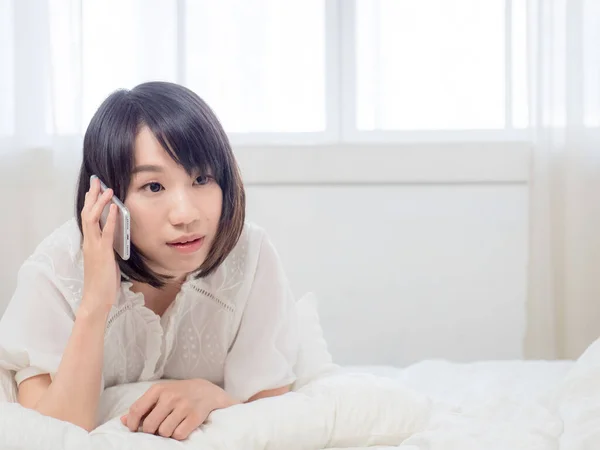 Evdeki Bir Odanın Yatağında Cep Telefonuyla Konuşan Güzel Asyalı Bir — Stok fotoğraf