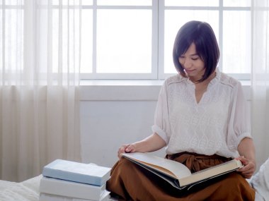 Yatakta kitap okuyan kız.