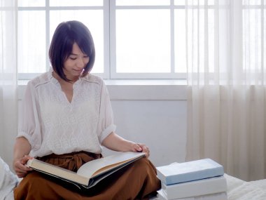 Yatakta kitap okuyan kız.