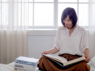 Yatakta kitap okuyan kız.