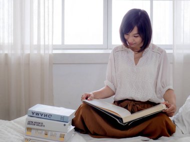 Yatakta kitap okuyan kız.