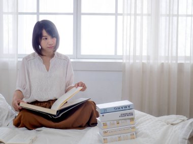 Yatakta kitap okuyan kız.