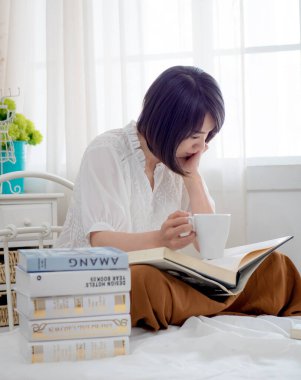 Yatakta kitap okuyan kız.