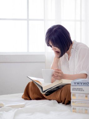 Yatakta kitap okuyan kız.