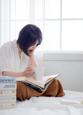 Yatakta kitap okuyan kız.