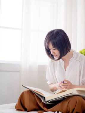 Yatakta kitap okuyan kız.