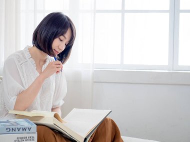 Yatakta kitap okuyan kız.