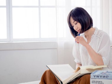 Yatakta kitap okuyan kız.