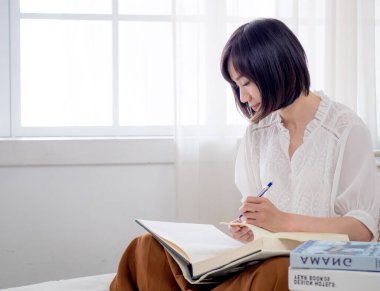 Yatakta kitap okuyan kız.