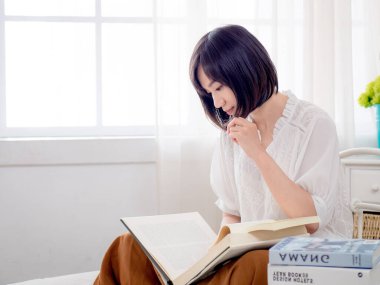 Yatakta kitap okuyan kız.