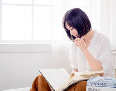 Yatakta kitap okuyan kız.