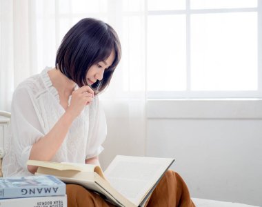 Yatakta kitap okuyan kız.