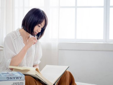 Yatakta kitap okuyan kız.