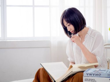 Yatakta kitap okuyan kız.