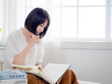 Yatakta kitap okuyan kız.