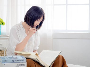 Yatakta kitap okuyan kız.