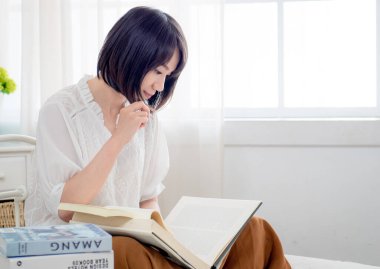 Yatakta kitap okuyan kız.