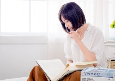 Yatakta kitap okuyan kız.