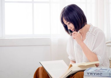 Yatakta kitap okuyan kız.