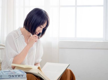 Yatakta kitap okuyan kız.