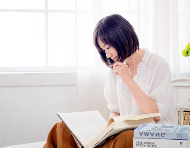 Yatakta kitap okuyan kız.