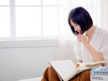 Yatakta kitap okuyan kız.