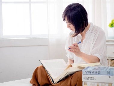 Yatakta kitap okuyan kız.