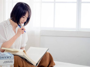 Yatakta kitap okuyan kız.