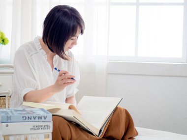 Yatakta kitap okuyan kız.