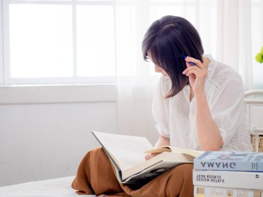 Yatakta kitap okuyan kız.