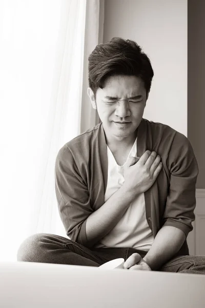 Young asian man having heart attack