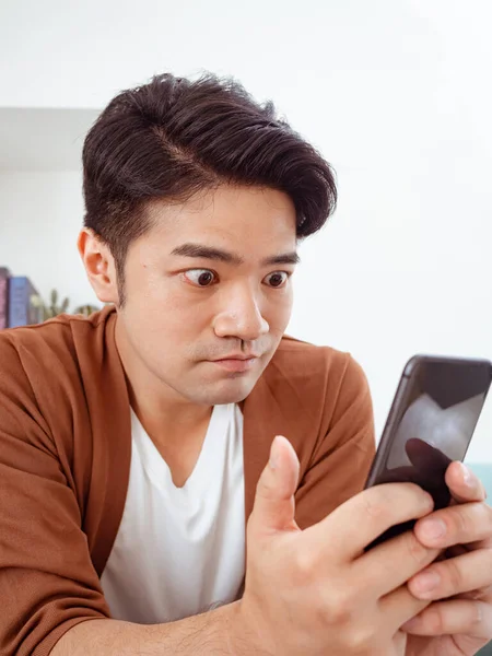 Happy and wow face of Asian man use smartphone.