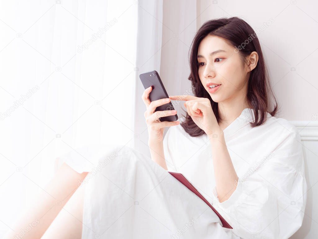 Young asian woman using smartphone at home